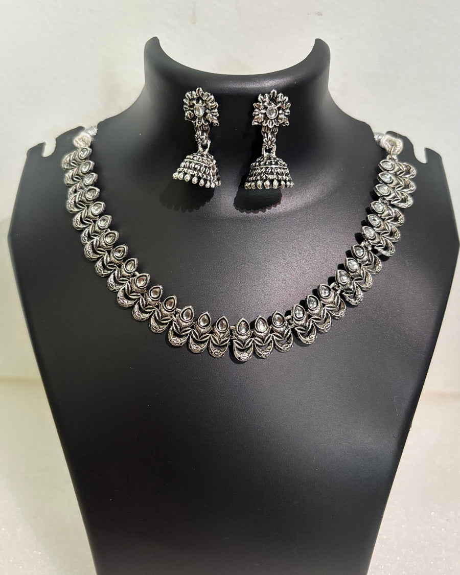 Oxidised teardrop motif necklace with engraved leaf details and matching floral jhumka earrings